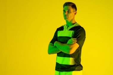 Turuncu ışıkta kollarını kavuşturan beyaz erkek rugby oyuncusu. Spor, hareket, eğitim ve aktif yaşam tarzı kavramı.