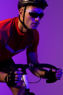 Pembe ışıkta bisiklet süren beyaz erkek bisikletçi. Spor, hareket, eğitim ve aktif yaşam tarzı kavramı.