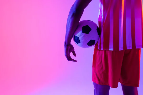 Αφροαμερικάνος Ποδοσφαιριστής Ποδόσφαιρο Πάνω Από Νέον Ροζ Φωτισμό Αθλητισμός Κίνηση — Φωτογραφία Αρχείου