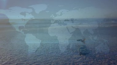 Sahildeki dünya haritasının animasyonu. Doğa, uyum ve dijital arayüz kavramı dijital olarak oluşturulmuş video.