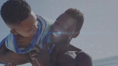 Afrika kökenli Amerikalı bir adam ve oğlunun plajda birlikte oynadığı animasyonlar. Yaşam tarzı, aile ve ışık konsepti dijital olarak oluşturulmuş video.