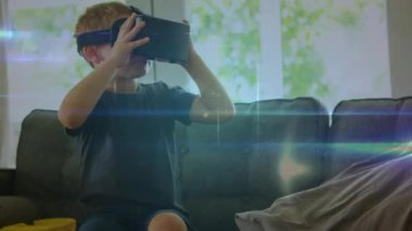 VR kulaklık takan beyaz bir çocuğun evdeki kanepede oturması ile ilgili bağlantılar. Küresel ağ ve iş teknolojisi kavramı