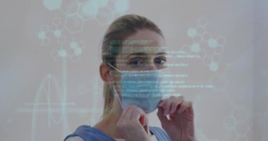 Yüz maskesi olan beyaz bir kadının veri işleme animasyonu. Küresel iş ve dijital arayüz kavramı dijital olarak oluşturulmuş video.