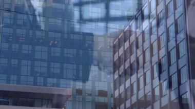 İş adamlarının arka plandaki yüksek binalara el sıkışırken çekilmiş ortak video görüntüleri. İş ve teknoloji kavramı