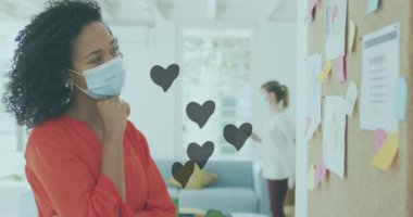 Afrika kökenli Amerikalı bir kadının ofisinde notlar okuyan birden fazla kalp ikonu var. Kalp ayı farkındalığı ve iş teknolojisi kavramı