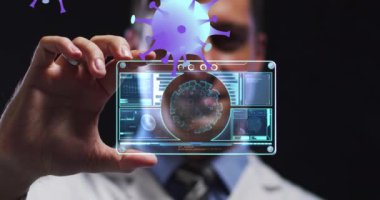 Animation of purple virus cells over caucasian male lab worker with digital card with virus data. Science, medicine and covid 19 pandemic concept digitally generated video.