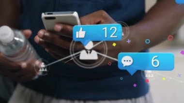 Animation of media icons over african american businessman using smartphone. Global business and digital interface concept digitally generated video.