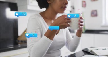 Animation of social media icons over african american women drinking coffee. Social media and communication concept digitally generated video.