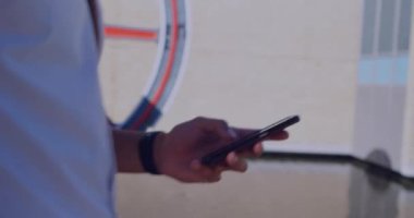 Akıllı telefon kullanan Afro-Amerikan bir adamın elinden çıkan sosyal medya tepkilerinin animasyonu. Sosyal medya, ağ, iletişim ve teknoloji konsepti dijital olarak oluşturulmuş video.