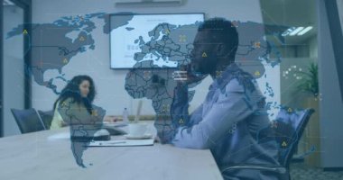 Dünya haritasının animasyonu ve Afrika kökenli Amerikalı bir adamın ofisinde çalışan ikonlar. İş, finans, ekonomi ve teknoloji konsepti dijital olarak oluşturulmuş video.