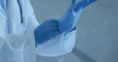 Yüz maskesi ve eldiven takan beyaz erkek doktor üzerindeki kimyasal yapıların animasyonu. Küresel covid 19 salgın, ilaç ve sağlık hizmetleri konsepti dijital olarak oluşturulmuş video.