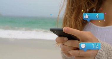 Akıllı telefon kullanan beyaz bir kadının elleri üzerinden sosyal medya tepkilerinin animasyonu. Sosyal medya, ağ, iletişim ve teknoloji konsepti dijital olarak oluşturulmuş video.