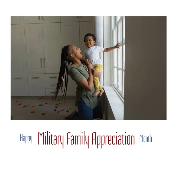 Image of military family appreciation month over african american mother and son at home. Military, army, soldiers and american patriotism concept.