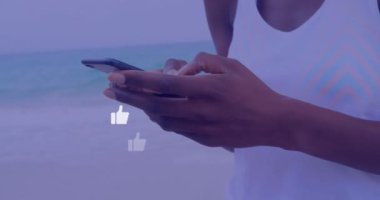 Akıllı telefon kullanan melez bir kadının elleri üzerinden sosyal medya tepkilerinin animasyonu. Sosyal medya, ağ, iletişim ve teknoloji konsepti dijital olarak oluşturulmuş video.