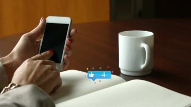 Akıllı telefon kullanan beyaz bir kadının elleri üzerinden sosyal medya tepkilerinin animasyonu. Sosyal medya, ağ, iletişim ve teknoloji konsepti dijital olarak oluşturulmuş video.