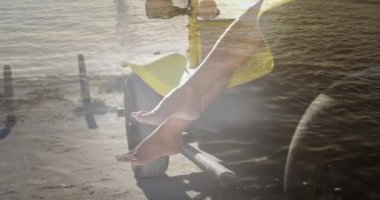 Animation of legs of african american woman in car on beach. Holidays, vacations and relax concept digitally generated video.