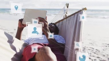 Animation of connections over relaxed african american man reading book in hammock on beach. Network, connections, holidays and relax concept digitally generated video.
