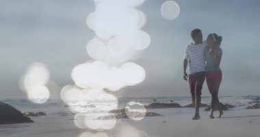 Sahilde yürüyen mutlu Afrikalı Amerikalı çiftin üzerindeki noktaların animasyonu. Tatiller, tatiller ve rahatlama konsepti dijital olarak oluşturulmuş video.