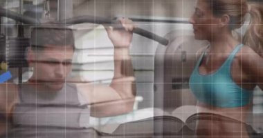 Spor salonunda çalışan beyaz formda bir adama karşı hareket eden mavi grafiklerin animasyonu. Küresel iş verileri ve fitness teknolojisi kavramı