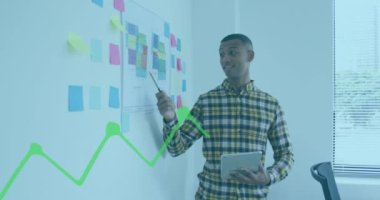 Animation of financial graphs and data over biracial man working in office. Business, finance and economy concept digitally generated video.