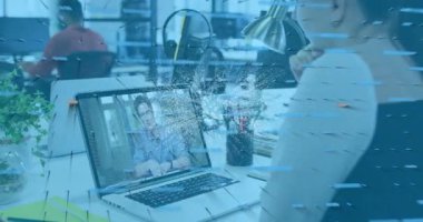 Animation of nft and graphs over caucasian woman having video call on laptop. Digital resources, finance, business and technology concept digitally generated video.