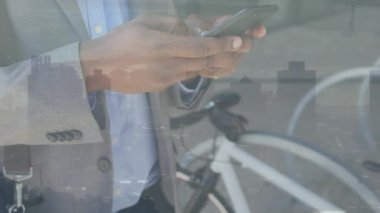 Animation of african american businessman using smartphone over cityscape. Global business, finances and digital interface concept digitally generated video.