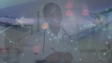 Animation of network of connections over african american female doctor smiling. Global medicine and digital interface concept digitally generated video.