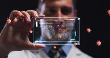 Animation of orange virus cells over caucasian male lab worker with digital card with virus data. Science, medicine and covid 19 pandemic concept digitally generated video.