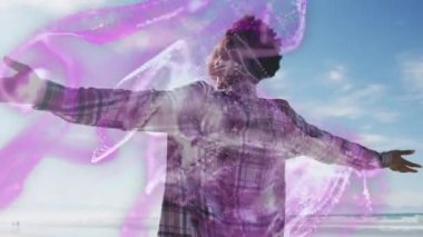 Animation of waves over happy african american woman with raised hands. Holidays, vacations and relax concept digitally generated video.