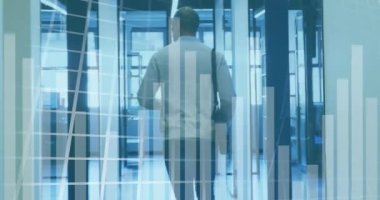 Animation of financial graphs and data over back view of caucasian man walking camera in office. Business, finance and economy concept digitally generated video.