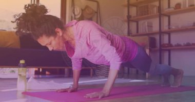 Animation of aries star sign over caucasian woman exercising at home. Astrology and healthy lifestyle concept digitally generated video.