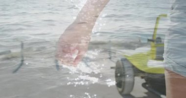 Animation of light over hands of caucasian couple walking on beach. Holidays, vacations and relax concept digitally generated video.