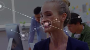 Animation of network of connections over happy caucasian woman in office. Business, network, connections, cooperation and communication concept digitally generated video.