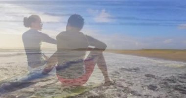 Sahilde oturan mutlu Afro-Amerikan çifti animasyonu. Tatiller, tatiller, aşk, ilişki ve rahatlama konsepti dijital olarak oluşturulmuş video.