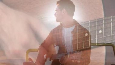 Sahilde gitar çalan mutlu beyaz adamın üzerindeki ışıkların animasyonu. Tatiller, tatiller ve rahatlama konsepti dijital olarak oluşturulmuş video.