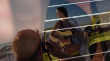 Deniz manzarası üzerinde gitarlı mutlu beyaz çiftin animasyonu. Tatiller, tatiller ve rahatlama konsepti dijital olarak oluşturulmuş video.