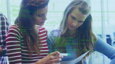 Animation of data and globe over caucasian female coworkers in office. Business, network, communication and technology concept digitally generated video.