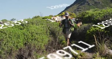 Animation of numbers over african american man hiking. Sport, fitness and technology concept digitally generated video.