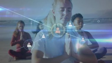 Animation of network of connections with icons over diverse women meditating. Global sport and digital interface concept digitally generated video.