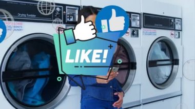 Animation of like text over african american woman using smartphone at public laundromat. Social media networking and technology concept