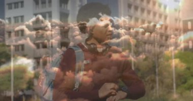Animation of clouds over african american businessman with smartwatch. Global business and digital interface concept digitally generated video.