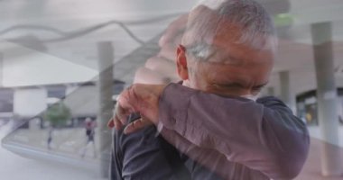 Composite video of caucasian man sneezing against mid section of a person typing on keyboard. Covid-19 pandemic and education concept