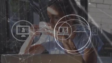 Animation of data processing with icons over caucasian businesswoman in office. Global business and digital interface concept digitally generated video.