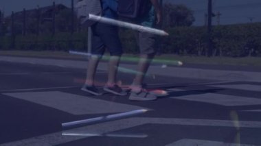 Karşıdan karşıya geçerken koşan öğrencilerin üzerine düşen renkli kalemlerin birleşik videosu. Okul ve eğitim kavramı