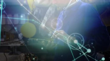 Animation of network of connections over caucasian male worker using tablet. Global business and digital interface concept digitally generated video.