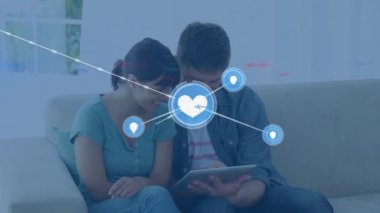 Tablet kullanan farklı çiftler üzerindeki simgelerle bağlantı ağının animasyonu. Küresel eğitim ve dijital arayüz kavramı dijital olarak oluşturulmuş video.