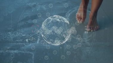 Animation of spinning globe with molecule, circles against african man walking at beach. Digital composite, multiple exposure, digital interface, technology, global science, wellbeing, leisure time.