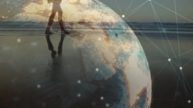 Günbatımında plajda yürüyen beyaz bir kadın üzerindeki dünya ve bağlantıların animasyonu. Spor, sağlıklı, aktif yaşam tarzı, bağlantılar ve teknoloji konsepti dijital olarak oluşturulmuş video.