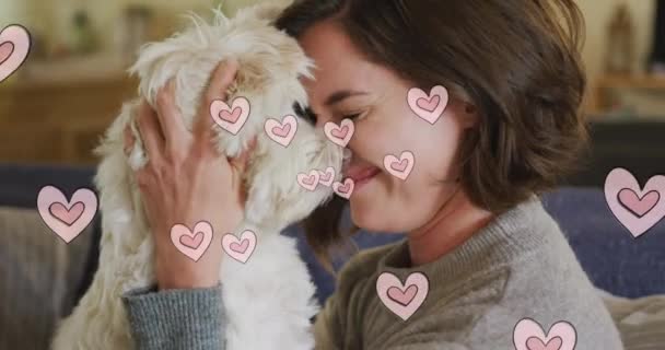 Multiple Pink Heart Icons Floating Caucasian Woman Kissing Her Dog — Vídeo de stock