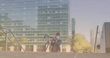 Spots of light against asian man carrying his bicycle walking up the stairs. pedal day awareness concept